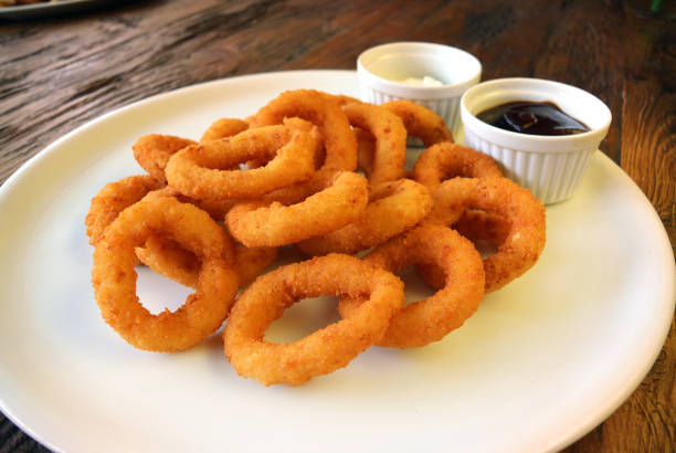 istock Fried Onion Rings and sauces on wooden table 826574376