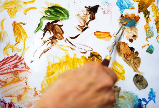 istock Artist's Hand Mixing Oil Paints on Palette (Close-Up) 826574516