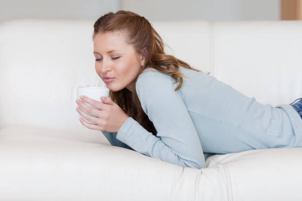 istock Young woman enjoying a coffee break on the sofa 826574808