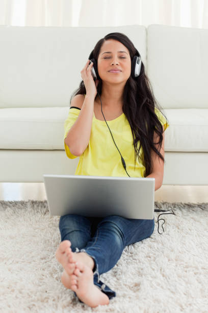 istock Pretty Latin enjoying music on a laptop 826581078
