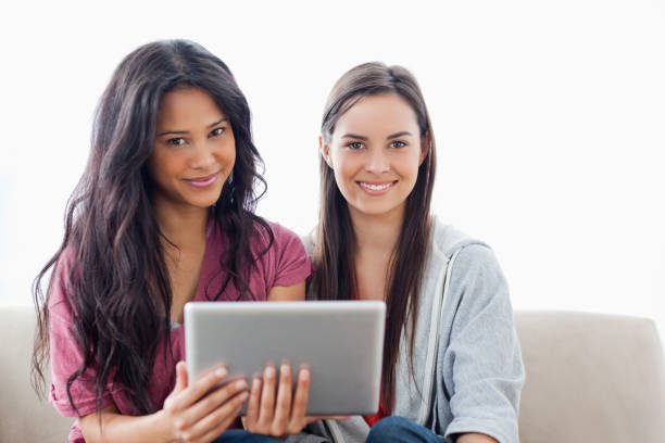 istock Two ladies with a tablet pc in hand looking at the camera 826582196