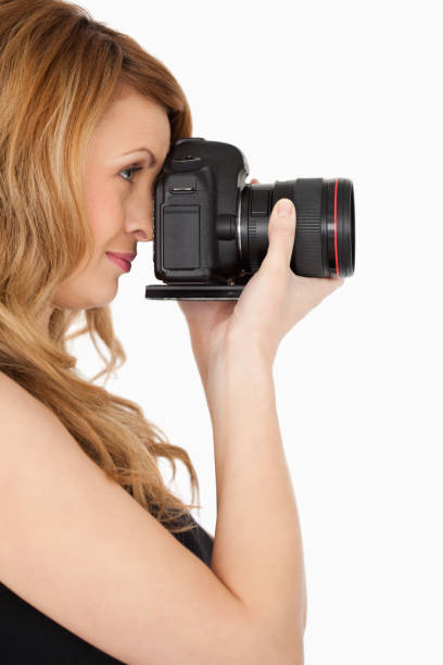 istock Lovely blondhaired woman taking a photo with a camera 826582340