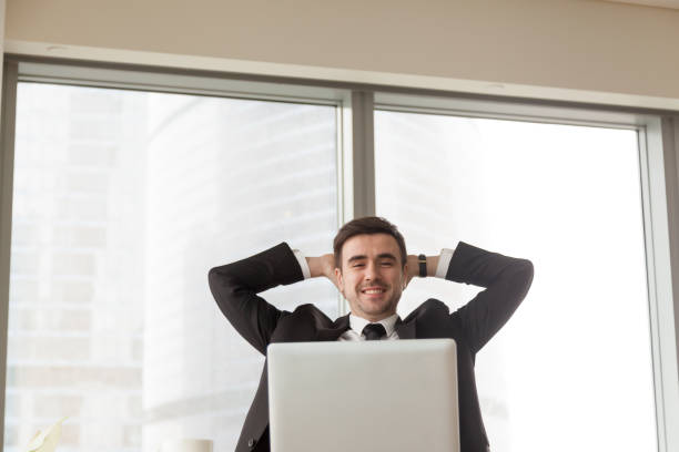 istock Relaxed happy businessman sitting hands behind head looking at laptop 826582436