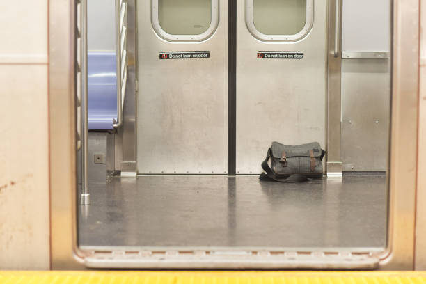 A lost or forgotten bag lays on the subway floor.