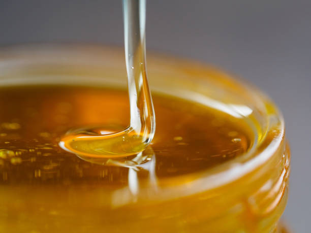 istock Honey falling in jar extreme close up 826599034