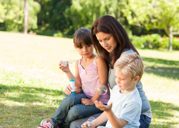 istock Family blowing bubbles in the park 826599518