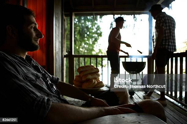 Friends Grilling On Deck At Cabin Stock Photo - Download Image Now - Grilled, Outdoors, Barbecue Grill