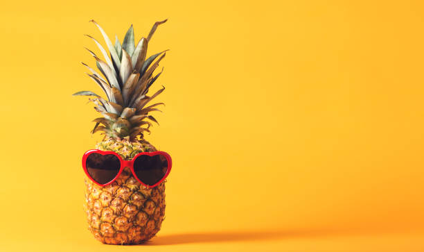 istock Pineapple with sunglasses on a bright yellow background 826613182