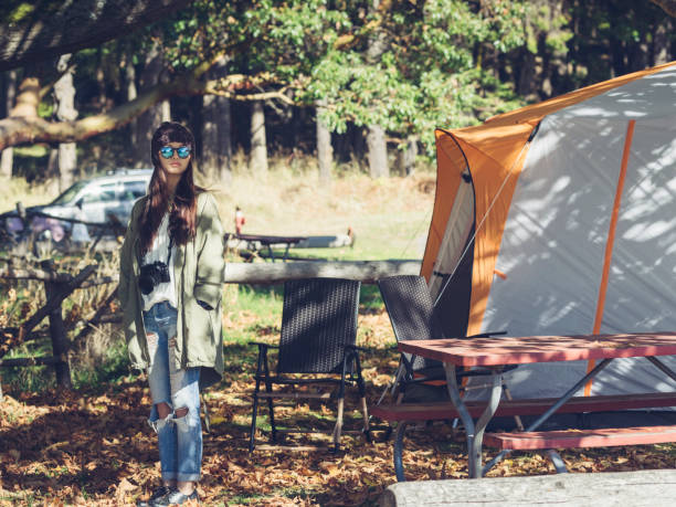 This is a photograph of a green dome camping tent set up in a grassy site surrounded by tall trees in the Washington & Jefferson National Forest in Virginia on a summer day.