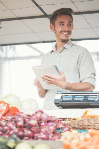 istock Smiling vendor on farmer's market using digital tablet 826621488