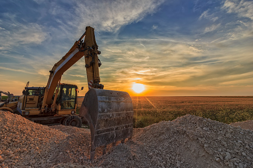 excavator in construction site at stunning sunset