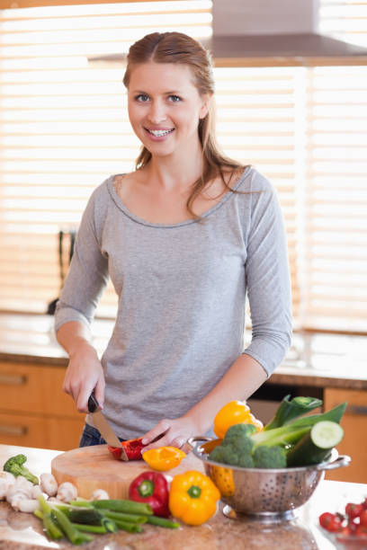 istock Smiling woman cutting ingredients for salad 826626650