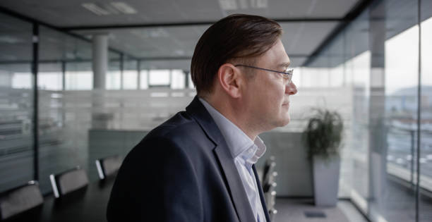 istock Businessman contemplating in empty conference room 826629656