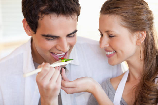 istock Man is tasting the meal his girlfriend is cooking 826629952