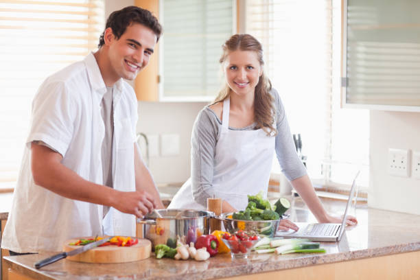 istock Couple using notebook to look up recipe 826630260