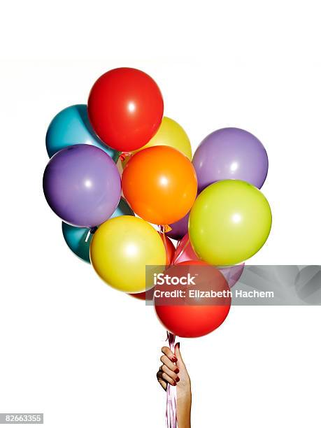 Hand Holding A Bunch Of Multicoloured Balloons Stock Photo - Download Image Now - Balloon, White Background, Holding