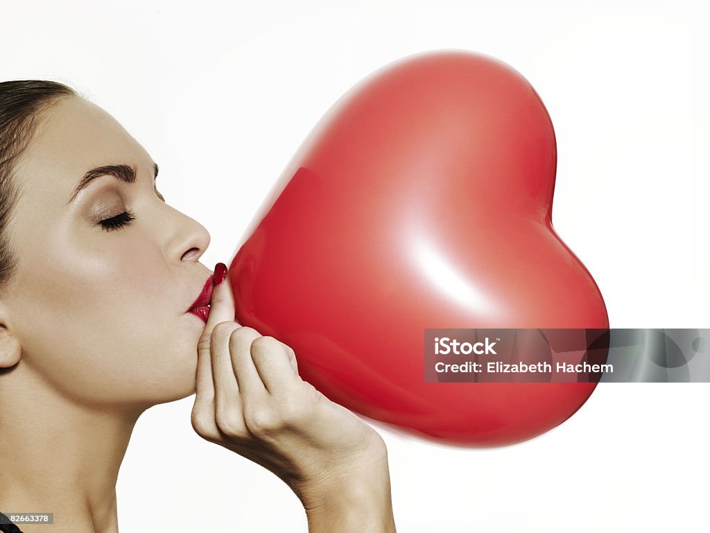 Mädchen Blasen auf einem roten herzförmigen Ballon - Lizenzfrei Herzform Stock-Foto