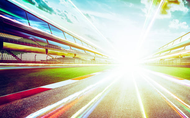 istock View of the infinity empty asphalt international race track  with light trail effect . evening scene . 826634468
