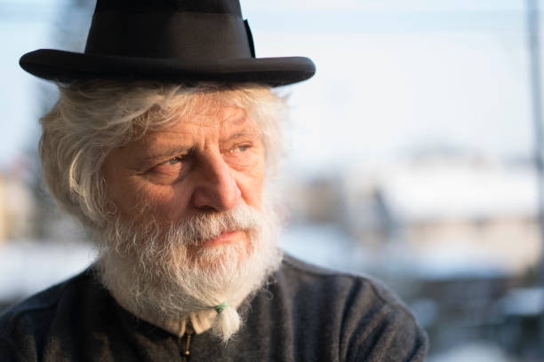 istock Senior with old hat on his head and beard brush 826634570