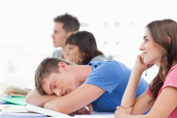 istock Three students listening in class with another student taking a nap 826635172