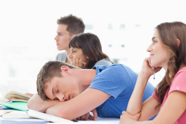 istock Four students in class as three pay attention one male student sleeps 826635182