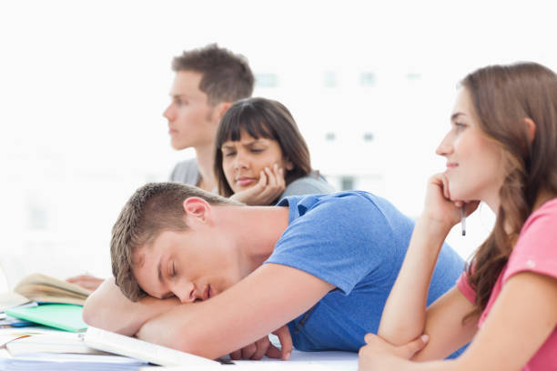 istock A sleeping student is being looked at by a confused fellow student 826635202