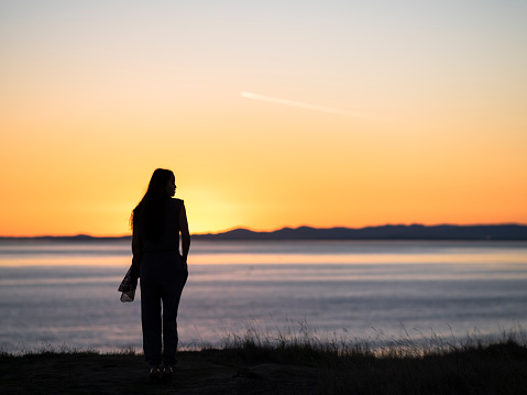 beautiful asian woman standing at Friday Harbor during sunset,san juan island,washington,usa.