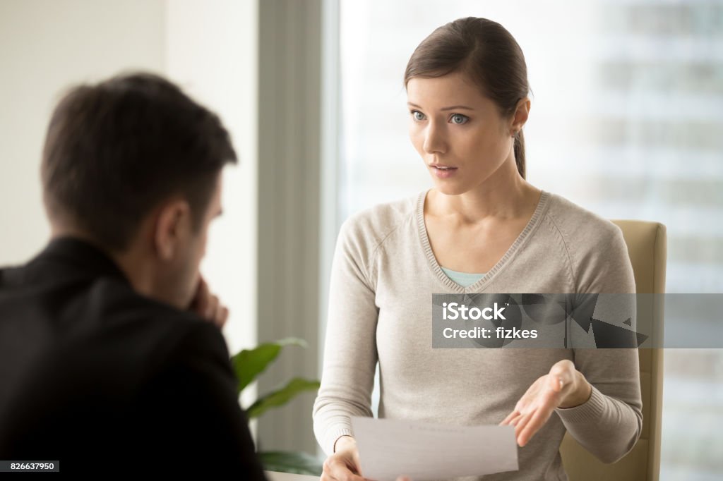 Irritated businesswoman disagree with bad contract, boss dissatisfied with report Irritated businesswoman holding paper, disagrees with bad contract terms, refuses to sign document, has questions claims to agreement conditions, boss dissatisfied with report or written work result Complaining Stock Photo