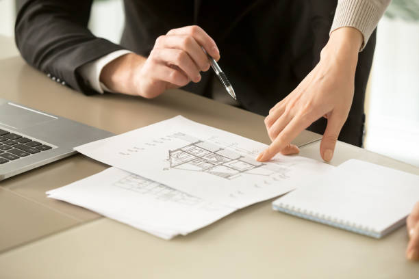 Architects discussing two-story house building plan, property appraisal, close up