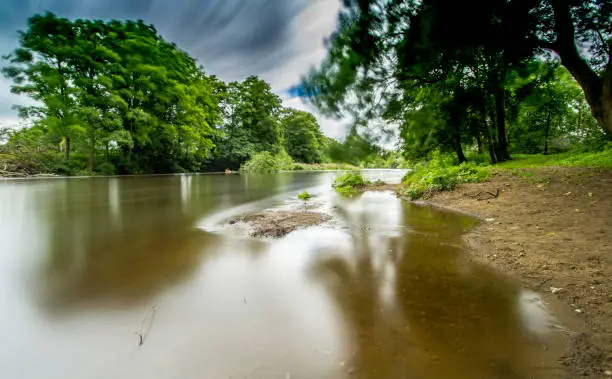 High water levels at the River Wharfe, Linton, West Yorkshire. Create nice reflections with wind blur on the trees.