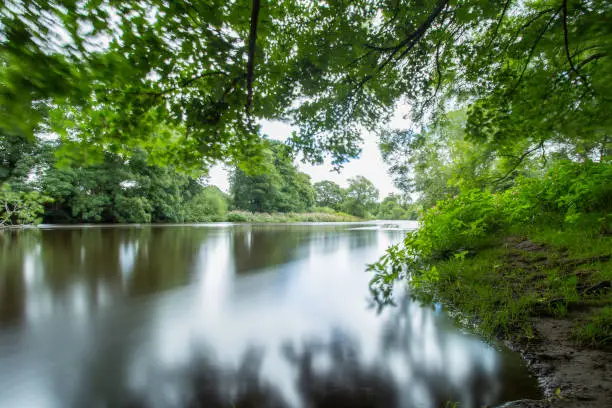Long exposure reflection shot through the trees at the River Wharfe, Linton, Yorkshire, United Kingdom.