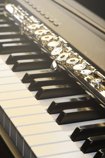 istock Piano and flute with golden shine and sheet music.   Horizontal Composition.Front view 826639532