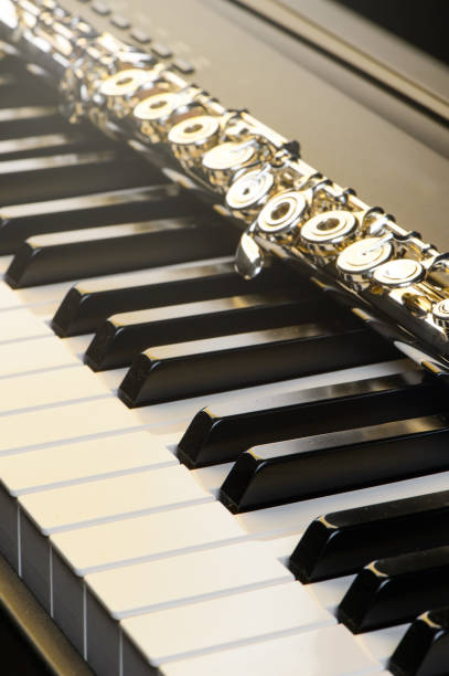 istock Piano and flute with golden shine and sheet music.   Horizontal Composition.Front view 826639584