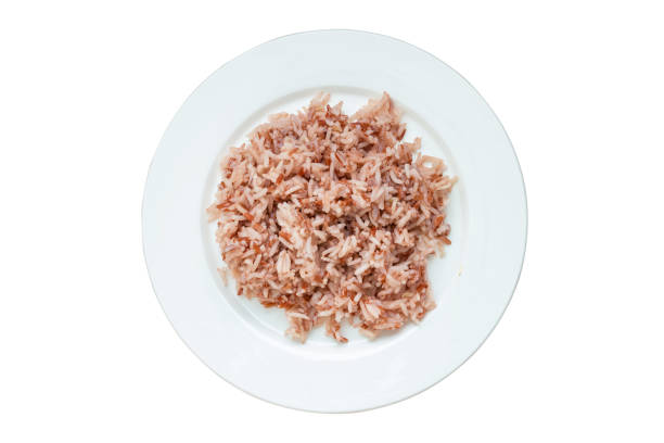 Brown rice in white plate ready to eat, isolated on white background with clipping path