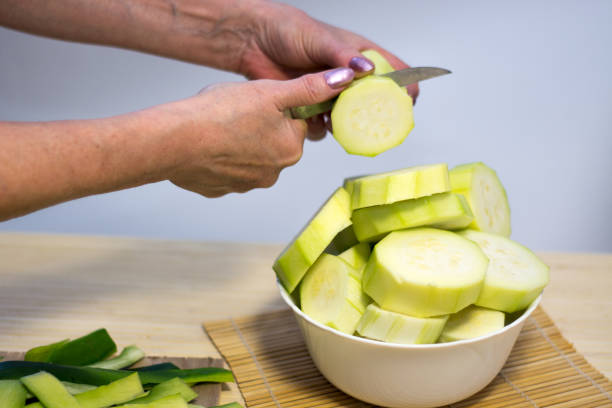 istock Woman cooking and slicing fresh vegetables on a rustic kitchen worktop, healthy eating concept, flat lay 826645812