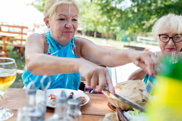 istock Senior friends having lunch outdoors 826649534