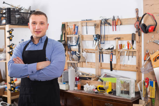 istock Portrait of happy young handsome carpenter in uniform in workshop. 826656566