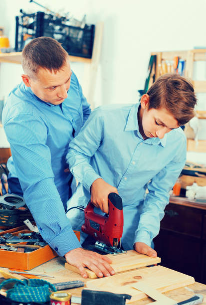 istock Family of two working with wood plank in workshop 826656576