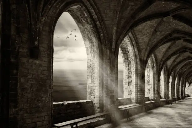 Photo of fantasy monastery archway with view to ocean an sunrays