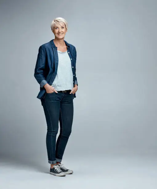 Studio portrait of a mature woman posing against a grey background