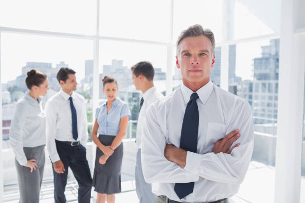 istock Serious boss with arms folded standing in a modern office 826661704