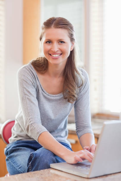 istock Woman typing on her laptop in the kitchen 826662454