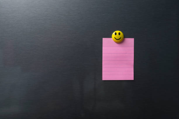 Empty pink paper on refrigerator door with smilling face on magnet. Empty pink paper on refrigerator door with smilling face on magnet. magnet photos stock pictures, royalty-free photos & images