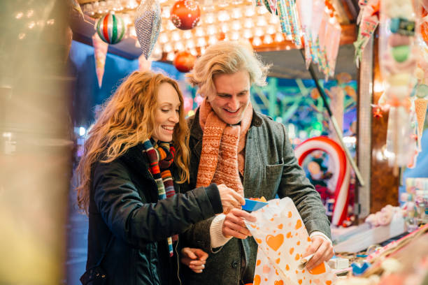 Buying Sweets At Winter Market Happy couple are buying a pick and mix from a sweet stall in the winter market. pick and mix stock pictures, royalty-free photos & images