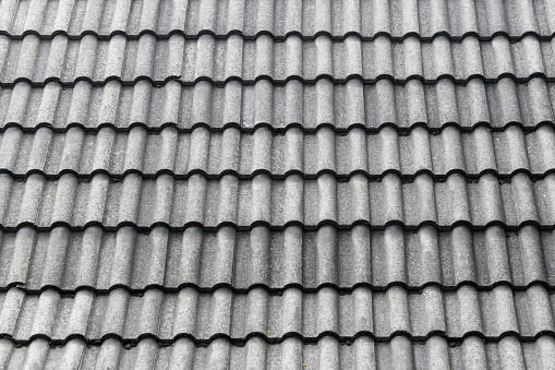 Texture with gray roof tiles. Roof protecting cover material arranged in rows.