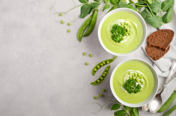 istock Green pea soup in bowls on grey concrete or stone background 826681902