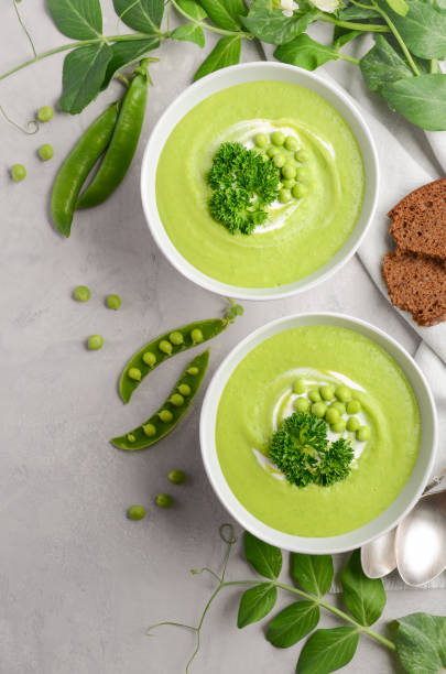 istock Green pea soup in bowls on grey concrete or stone background 826681916