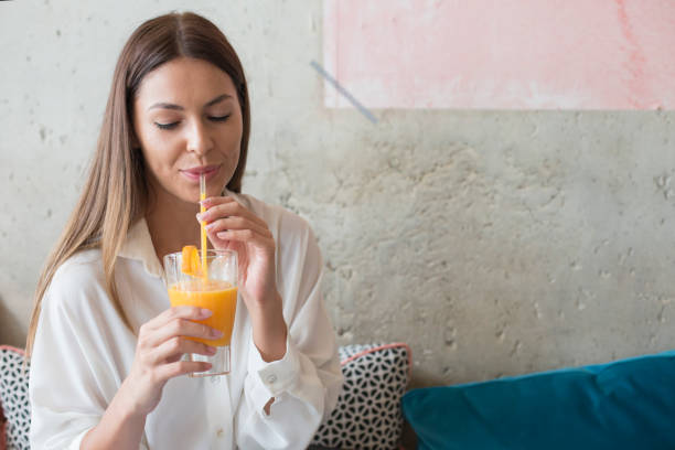 istock Woman drinking juice through drinking straw 826689932