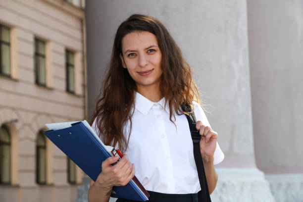 istock Girl student holding a folder in hands, college student, a school, 826705650