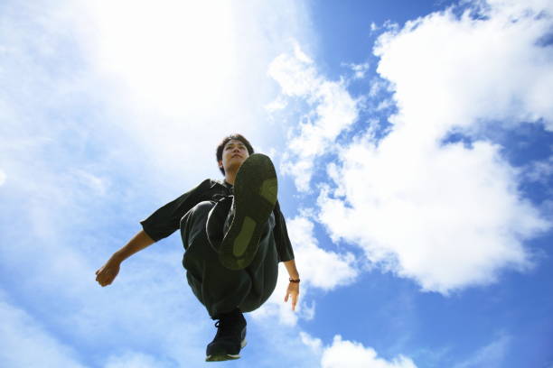 woman legs in stylish jumping boots in park, kangoo jumps close-up view